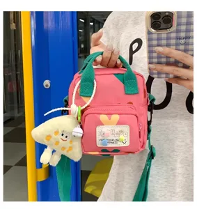 Cute pink canvas crossbody bag with green handle and playful mushroom pendant detail.