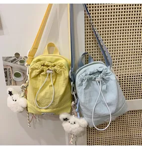 Kleiner süßer Rucksack für Damen, Freizeittasche mit Kordelzug und niedlichem Plüschtieranhänger.