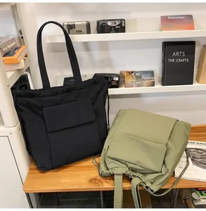 Casual nylon tote tas met trekkoordsluiting en voorzakdetails voor dagelijks gebruik.