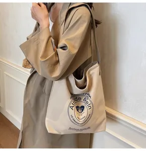 Canvas shoulder bag detail showing vintage letter print and spacious capacity design.