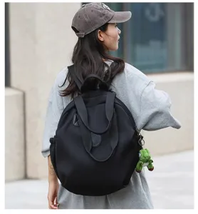 Vue détaillée du sac à dos décontracté en nylon noir avec bretelles et poignées.