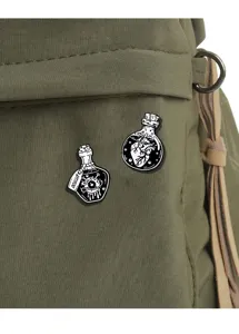 Close-up of gothic punk enamel pins with dark potion bottle designs for cool clothes decoration.