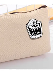 Close-up of a punk gothic skull metal enamel pin brooch, unique black and white design.