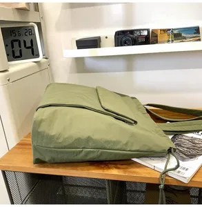 Groene casual shopper schoudertas detail, minimalistische tas met trekkoord en voorzak.