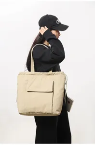Gedetailleerd zijdezicht van een beige minimalistische canvas tote bag met trekkoord en voorzak.