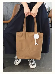 Vintage canvas tote bag for women, large capacity casual shoulder bag with cute fluffy pendant.