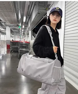 Grand sac de sport gris pour homme et femme, parfait pour le voyage et le fitness.