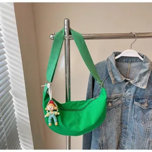 Grüne Segeltuch Halbmond Umhängetasche mit Puppenanhänger, lässige tägliche Pendler Schultertasche.