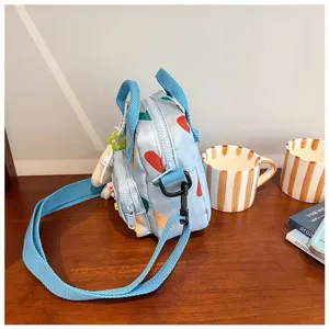 Detailed view of the cute light blue canvas shoulder bag featuring playful heart prints and straps.