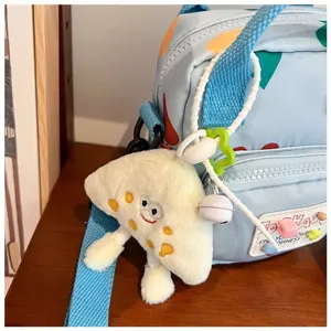 Cute canvas shoulder bag detail shot with fluffy plush charm and sweet strap accessories.