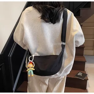 Lässige schwarze Segeltuchtasche für Damen, leichte Freizeittasche mit niedlichem Puppenanhänger.
