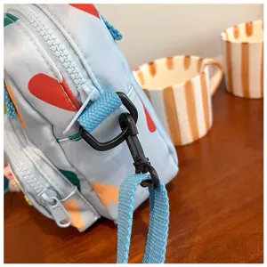 Canvas cross body bag detail shot showing strap, zipper and metal hook hardware accessories.
