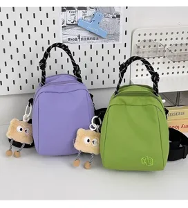 Chic casual canvas crossbody bag detail, compact mini handheld purse with cute plush charm.