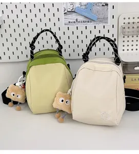 Lightweight canvas shoulder bag for women, casual crossbody shell bag with cute plush pendant.