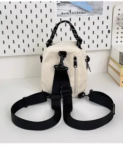 Canvas mini backpack detail showing adjustable straps and front zipper pocket setup.