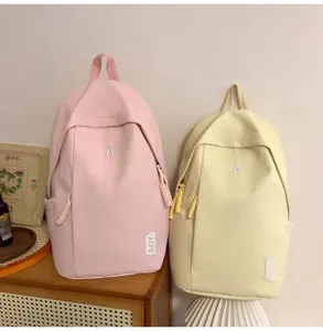 Detailansicht lässiger Rucksäcke in Rosa und Gelb mit minimalistischem Buchstaben-Design.