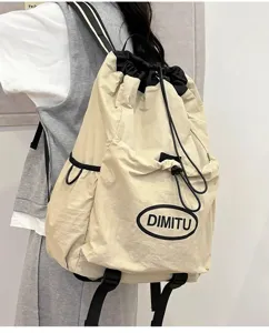 Vue détaillée du sac à dos léger à cordon en beige et noir, avec poche avant.