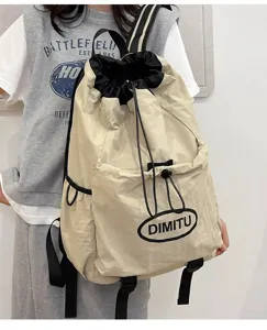 Vue détaillée d'un sac à dos léger kaki à cordon avec poche avant et bretelles confortables.