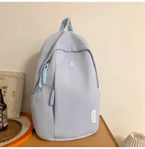 Ansicht des hellblauen Rucksacks mit Front-Buchstaben, großen Fächern und Reißverschlüssen.