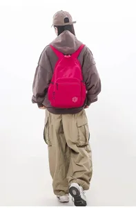 Detail view of the lightweight casual candy color backpack showing durable fabric and front pocket.