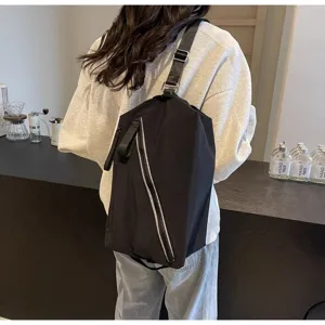 Primo piano dettagliato della borsa a tracolla nera casual con elegante cerniera asimmetrica.