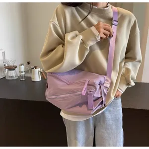 Vista di dettaglio della borsa a tracolla viola casual con cinghia e zip in scena accogliente.