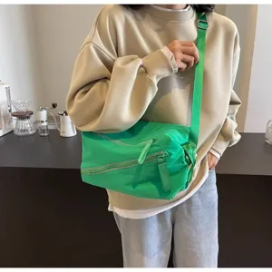 Vista dettagliata di una elegante borsa a tracolla verde in nylon in un bar accogliente.