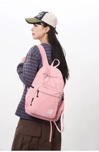 Casual pink lightweight waterproof travel backpack model showcase, featuring front zipper pocket.