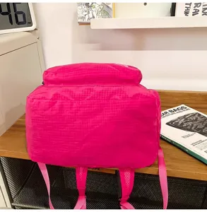 Detail view of the lightweight pink waterproof backpack showing durable straps and grid texture.