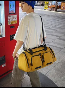 Detalle de la bolsa de viaje amarilla de gran capacidad con bolsillos y correas.