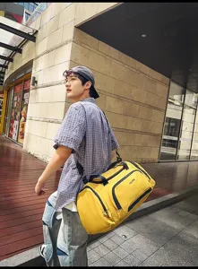 Vue détaillée d'un grand sac de voyage jaune dans une rue extérieure urbaine.
