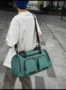 Vista detallada de la gran bolsa de viaje deportiva para hombre en verde con bolsillos.