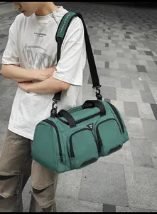 Detalle del modelo al aire libre con gran bolsa de viaje y deportiva de color verde.