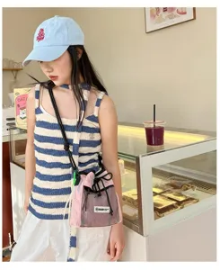 Detailansicht der modischen rosa Netztasche als Umhängetasche mit Kordelzug im Cafészenario.