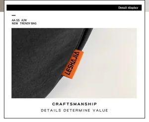 Detailed close-up view of the black large capacity crossbody dumpling bag with brand tag.