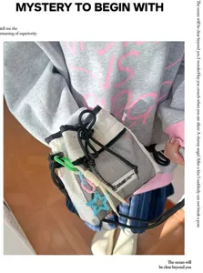 Lässige Kordelzug-Eimer Tasche mit Netz-Spleißen und bunten Anhängern für Damen und Herren im Alltag.