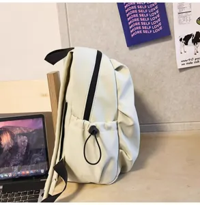 Side detail view of a minimalist casual cream backpack with black drawstring pocket and straps.