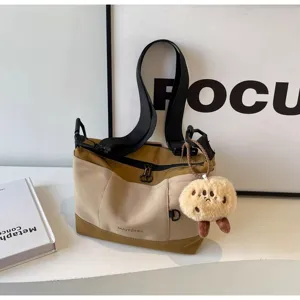 Vintage casual canvas messenger bag for women with cute plush cookie charm and front pocket.