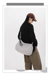 Detailansicht einer grossen Freizeitreisetasche mit Schultergurt vom Model getragen.