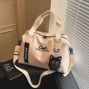 Detailansicht der beige Reisetasche mit süßem Katzen-Plüschanhänger und Gurten.