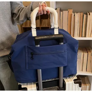Detail view of large travel duffel bag with trolley sleeve and white handles in use.
