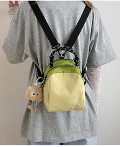 Casual canvas mini backpack for women, stylish dual-tone design with cute pendant for daily use.
