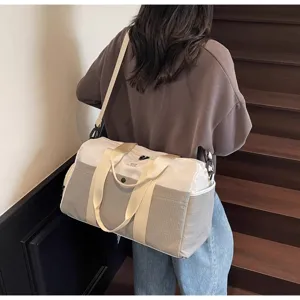 Vista dettagliata della grande borsa da viaggio grigia e bianca con robusti manici.