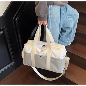 Dettaglio di un'elegante borsa da viaggio bicolore tenuta da una persona su una scala.