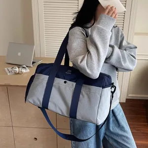 Vista dettagliata della grande borsa da viaggio a quadri blu con resistenti manici.