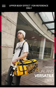 Outdoor detail shot of a large capacity yellow travel duffel gym bag with model display.