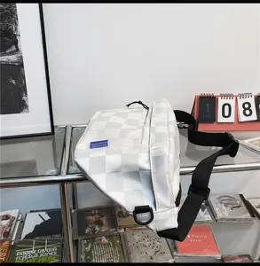 White checkered canvas crossbody bag detailed view, showing chest bag strap and D-ring hardware.