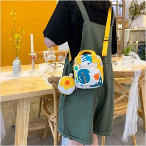 Detailed view of the cute canvas crossbody bag with cartoon graphic and matching coin purse.