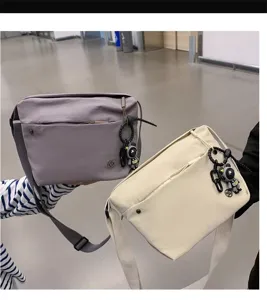 Nylon crossbody bag for women, lightweight waterproof canvas shoulder bag with astronaut pendant.
