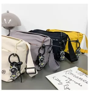 Casual nylon crossbody bag with cute astronaut pendant, lightweight and waterproof daily use.